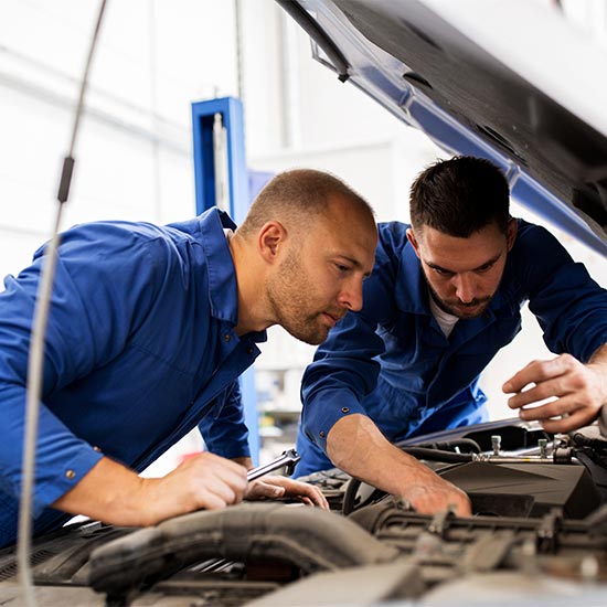 Two auto technicians under hood