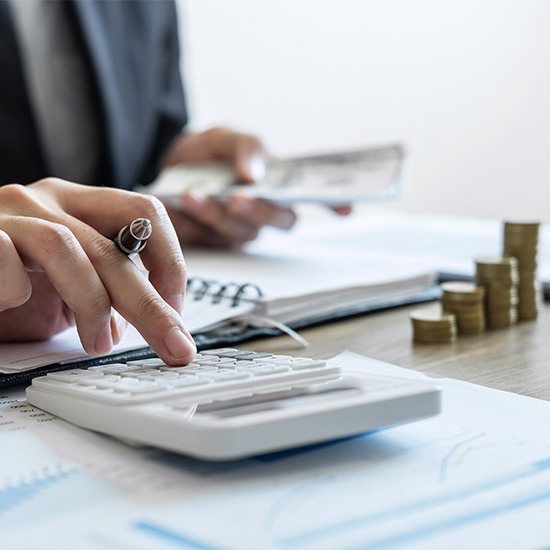 Person with cash and calculator doing accounting